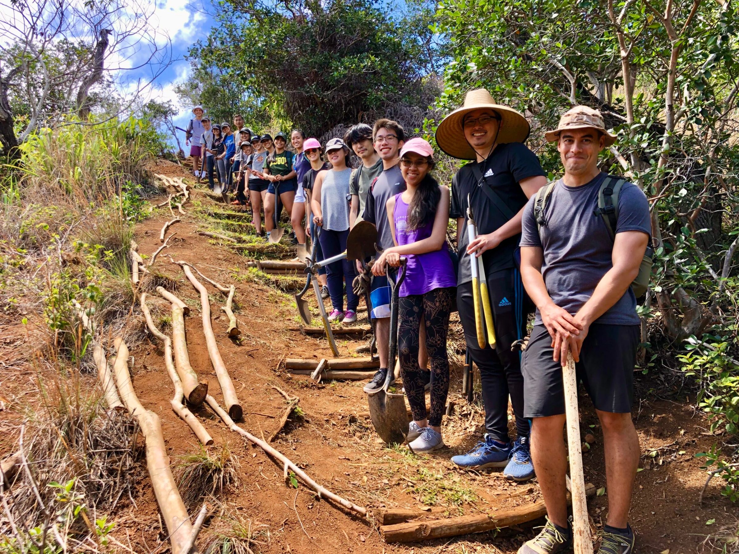 a group of people standing on a dirt road