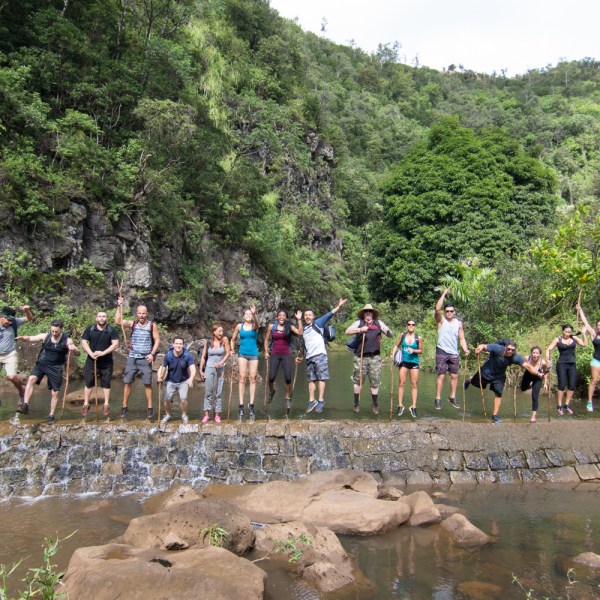 a group of people standing next to a river