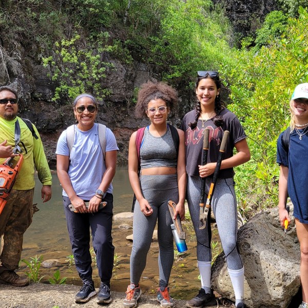 a group of people standing next to a tree