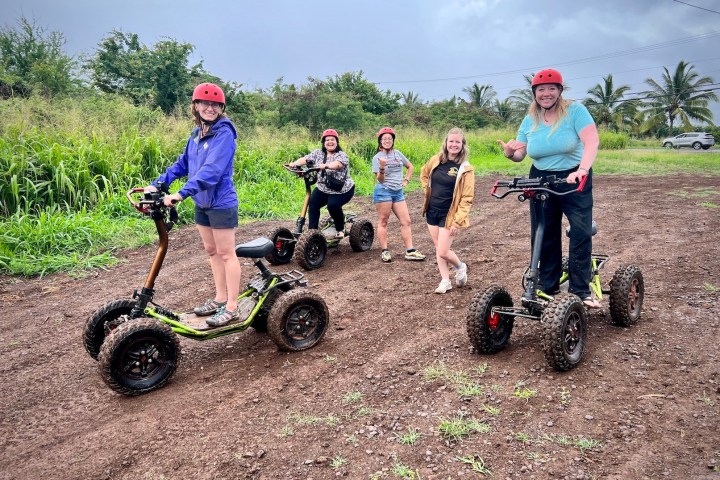 a group of people riding a motorcycle down a dirt road